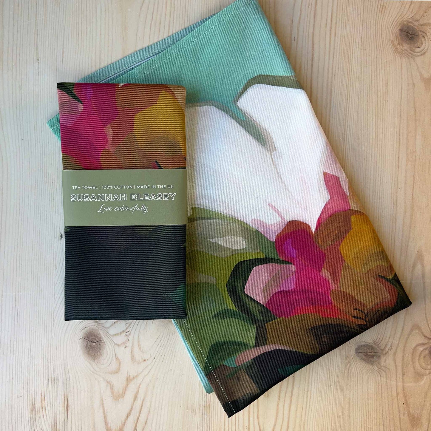 british tea towels with abstract floral design on teal background