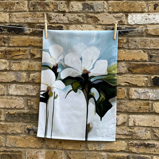 light blue floral cotton teal towel hanging against brick wall